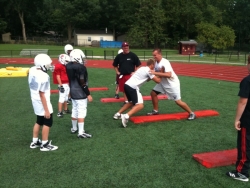 Football players participating in a tackling drill